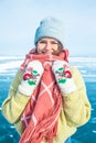 Portrait of a young female wonderer in fashionable hat and mittens and scarf looking in camera