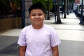 Young Filipino boy pose for the camera while at a business district