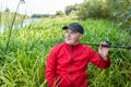 Portrait of a young fisherman in a thicket of reeds with a spinning rod