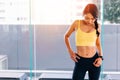 Portrait of young fit Asian woman standing in gym, hands on hips pose. Fitness female model image Royalty Free Stock Photo