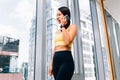 Portrait of young fit woman talking on the hone at high rise gym. Female fitness model image