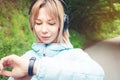 Portrait Young fitness woman looking at her smart watch while taking a break from sports training. Sportswoman checking Royalty Free Stock Photo