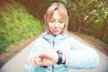 Portrait Young fitness woman looking at her smart watch while taking a break from sports training. Sportswoman checking Royalty Free Stock Photo