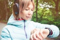 Portrait Young fitness woman looking at her smart watch while taking a break from sports training. Sportswoman checking Royalty Free Stock Photo