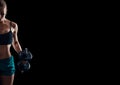 Portrait of a young fitness woman in sportswear doing workout with dumbbells on black background. Tanned athletic girl. A gre Royalty Free Stock Photo