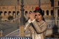 Portrait of young flamenco woman, Hispanic and brunette, with typical flamenco dance suit, with bullfighter jacket, playing palms