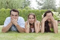 Portrait of young friends covering mouth, ears and eyes in park