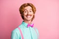 Portrait of young funky smiling cheerful happy gentleman wear suspenders and bow tie isolated on pink color background