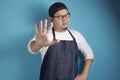 Portrait of young funny angry male Asian chef or waiter shows stop sign gesture Royalty Free Stock Photo