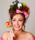 Portrait of young and funny woman with candy in her hands wearing interesting and creative hairstyle