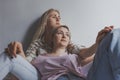 Portrait of young gay couple, girls lesbian sitting and hugging on background white wall. Concept of love, gay marriage and pride Royalty Free Stock Photo