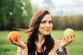 Portrait Of Young Girl. beautiful woman holding green apple and orange deciding what to choose Royalty Free Stock Photo