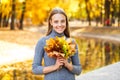 young girl with a bouquet of autumn leaves