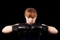 Portrait of young girl boxer putting hands together in black boxing gloves