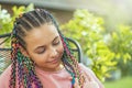 Portrait of young girl with colorful braids looking down