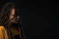 Portrait of a young girl with dreads on black background.
