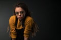 Portrait of a young girl with dreads on black background.