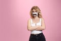 Portrait of young girl with emotion on her protective face mask on studio background. Beautiful female model