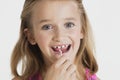 Portrait of young girl flossing teeth against gray background Royalty Free Stock Photo