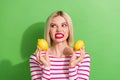 Portrait of young girl funny grimacing toothy smile hold yellow sour lemons look garden fresh fruits isolated on green Royalty Free Stock Photo