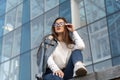 Portrait of young girl in glasses on background of glass facade of the building