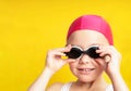 Portrait of a young girl in goggles and swimming cap.