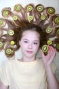 Portrait of a young girl with green slices of kiwi in her loose hair. Vertical. Close-up Royalty Free Stock Photo