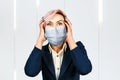 Portrait young girl has headache, wearing protective face mask prevent virus infection Royalty Free Stock Photo