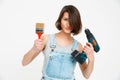 Portrait of young girl, holding painting brush and drill Royalty Free Stock Photo