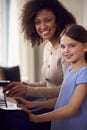 Portrait Of Young Girl Learning To Play Piano Having Lesson From Female Teacher Royalty Free Stock Photo