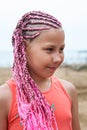 Portrait of young girl with long hair with dreds tressed pink fibre