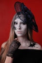 Portrait of a young girl with make-up in the style of Halloween. Black cracks are painted on the female face and body. The image o Royalty Free Stock Photo