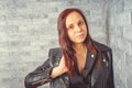 Portrait of a young girl without makeup on her face in a black jacket against a gray brick wall. Royalty Free Stock Photo