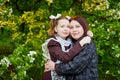 Portrait of young girl in an old school uniform of the USSR with a black dress and a white apron with her mother in the park.