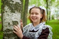 Portrait of a young girl in an old school uniform of the USSR with a black dress and a white apron. Teenager in the Park among the