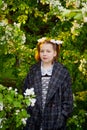 Portrait of a young girl in an old school uniform of the USSR with a black dress and a white apron. Teenager in the Park among the