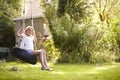 Portrait Of Young Girl Playing On Tire Swing In Garden Royalty Free Stock Photo