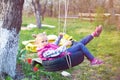 Portrait of young girl playing on tire swing in garden Royalty Free Stock Photo