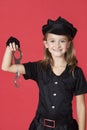 Portrait of young girl in police costume holding handcuffs against red background Royalty Free Stock Photo