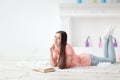 Portrait of young girl reading book lying on floor in living room Royalty Free Stock Photo