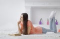 Portrait of young girl reading book lying on floor in living room Royalty Free Stock Photo