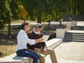 Portrait of young girl sitting with grandfather at park