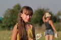 Portrait of young girl at summer meadow, collecting flowers Royalty Free Stock Photo