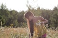 Portrait of young girl at summer meadow, collecting flowers Royalty Free Stock Photo