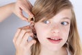 Portrait of a young girl trying hearing aids