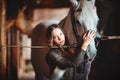 Portrait of a young girl in a village stables with a horse. Dressed in folk style Royalty Free Stock Photo