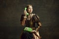 Portrait of young girl in vintage dress, royal person talking on retro phone against dark green background