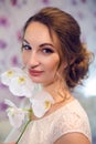 Portrait of a young girl in white dress with an Orchid flower Royalty Free Stock Photo