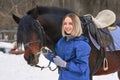 Portrait of a young girl with white hair next to a brown horse. The girl holds the horse and smiles. Close-up Royalty Free Stock Photo