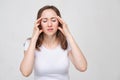 A portrait of a young girl in a white shirt holding his hands on his head. The concept of a strong head pain. headache Royalty Free Stock Photo